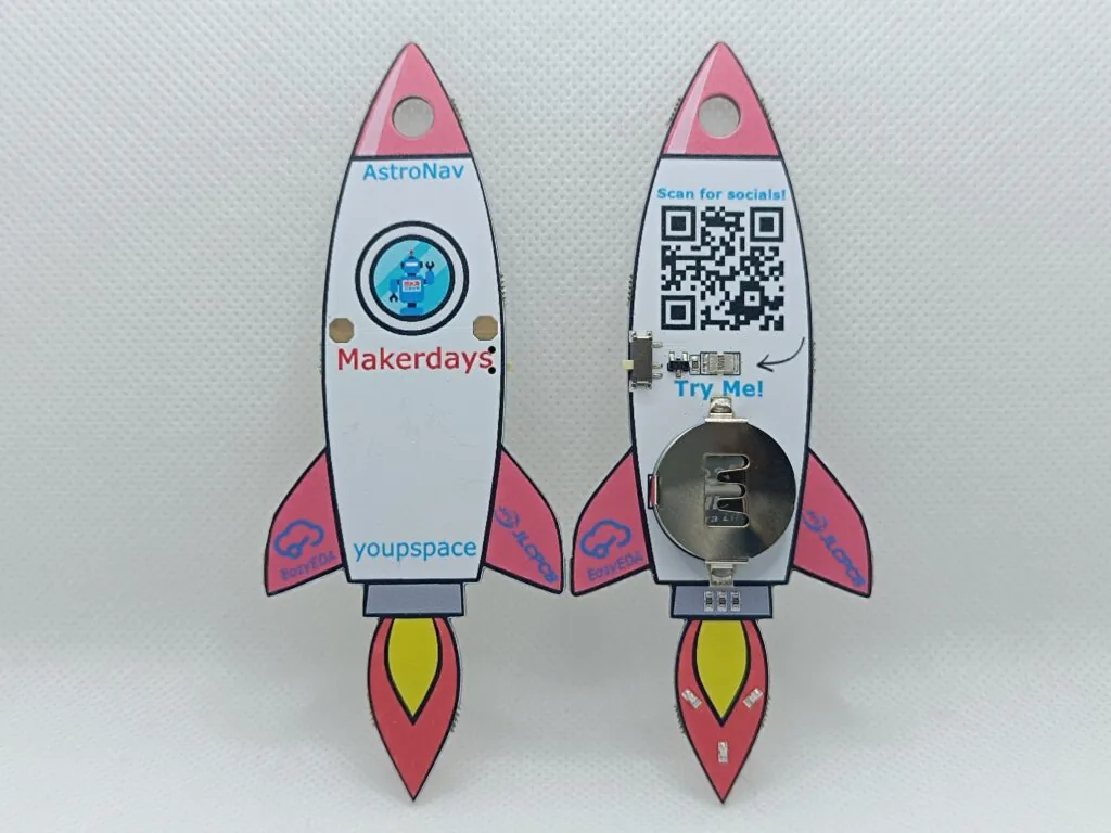Two rocket PCB keychains on display